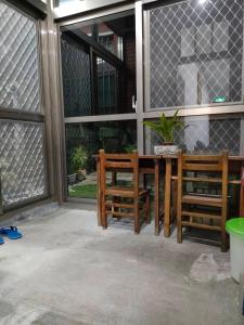 un patio con 2 sillas, una mesa y ventanas en 北斗合法古厝民宿 en Beidou