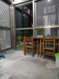 a patio with two chairs and a table and windows at 北斗合法古厝民宿 in Beidou