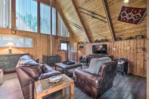 a living room with leather furniture and a tv at Ski-InandSki-Out Red River Cabin with Mtn Views! in Red River