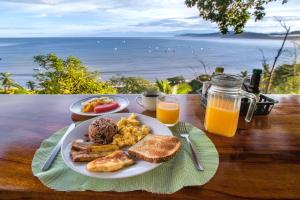 einen Teller mit Frühstückslebensmitteln und Meerblick in der Unterkunft Las Cotingas Ocean View in Drake