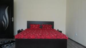 a bedroom with a bed with red sheets and red pillows at Ambiance Center in Bacău