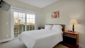 
a bedroom with a bed and a lamp on the wall at The Cliffside Resort Condominiums in Greenport
