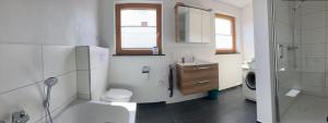 uma casa de banho com um WC, um lavatório e um chuveiro em Apartment Panoramablick em Bad Bergzabern