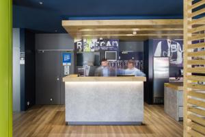 dos hombres parados en un mostrador en una cocina en Ibis Budget Braga Centro, en Braga