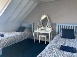 a bedroom with two beds and a table with a mirror at Glengarth house Room only accommodation in Wells