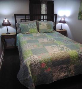 Una cama con edredón y dos lámparas. en 3-Br 2-Bath Family-Friendly Home -10 Min to Tulsa en Tulsa
