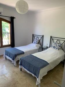 dwa łóżka w pokoju z oknem w obiekcie Spectacular views from this villa in Lapta w mieście Kirenia