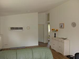 a living room with a green couch and a white wall at Behaglicher Bungalow für Mensch und Hund in Barkhagen