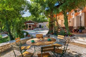 una mesa de madera y sillas en un patio en Villa ARTE-ŠHAM, en Ubasico