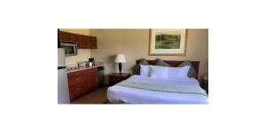 a hotel room with a bed and a sink at Wichita West Inn and Suites in Wichita