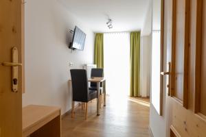 a room with a table and chairs and a television at Gasthof-Pension Riedl in Vöcklamarkt