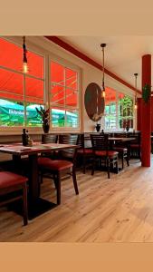 ein Esszimmer mit Tischen, Stühlen und Fenstern in der Unterkunft Hotel-Restaurant Babylon in Dierdorf