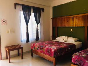 een slaapkamer met een bed en een raam bij Hotel Maya Balam in Xpujil