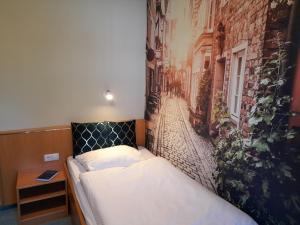 a bed in a room with a mural of a street at Gasthof Goldener Hirsch in Bühlerzell