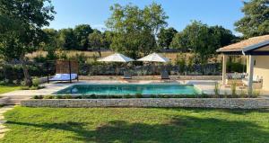 uma piscina num quintal com dois guarda-sóis em Casa Conte Istria em Kanfanar