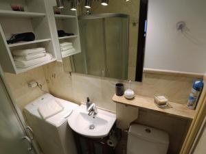 a bathroom with a sink and a toilet and a mirror at Apartament MGM Karmelicka in Warsaw