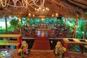 um restaurante com mesas e cadeiras num resort em Jardin del Eden Boutique Hotel em Tamarindo