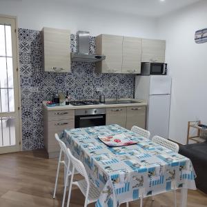 eine Küche mit einem Tisch mit Stühlen und einem Tisch sowie eine Küche mit einem Tisch in der Unterkunft Santorini house in San Pietro in Bevagna