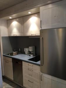a kitchen with white cabinets and a stainless steel refrigerator at Ferienhaus Schneider-Sepp in Ettal