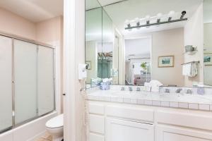 a bathroom with two sinks and a toilet and a mirror at 3 Bedroom! - Complex is on the beach with huge pool in Oceanside