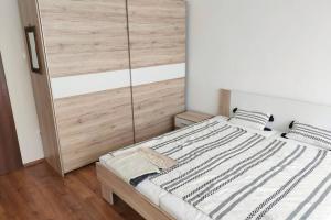a bedroom with a bed with a wooden headboard at Pláza Apartman - city center, free parking, free wifi in Debrecen