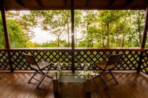 a table and two chairs on a porch with trees at Mirador Valle del General in La Ese