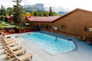 a swimming pool with a pool table and chairs at Miette Mountain Cabins in Jasper
