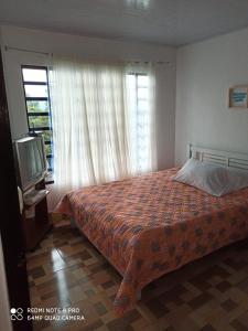 een slaapkamer met een bed, een tv en een raam bij Casa Azul Pinar del Rio San Agustín in San Agustín