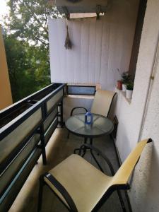 - Balcón con mesa pequeña y 2 sillas en Sunshine Apartmanok Szeged, en Szeged