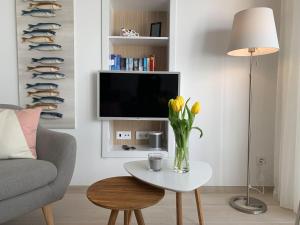 een woonkamer met een vaas met bloemen op een tafel bij CasaBlanca - Haus am Meer in Fuzeta