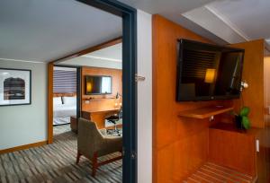 a hotel room with a desk and a tv and a room at Exe Miraflores in Lima