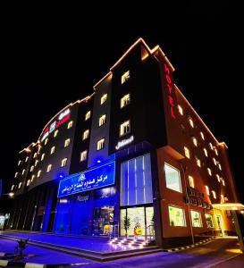 budynek z niebieskimi światłami na boku w obiekcie فندق لامير إن Lamer in Hotel w Szarurze