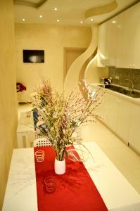 una cocina con una mesa con un jarrón de flores. en Apta Mihi B&B, en Vico Equense