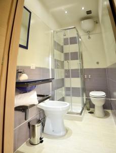 uma casa de banho com um WC e uma cabina de duche em vidro. em Apta Mihi B&B em Vico Equense