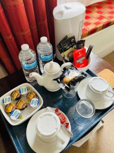 una mesa con una tetera y tazas y platos en ella en Corncroft Guest House, en Witney