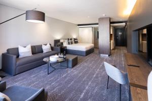 a living room with a couch and a bed at The Capital 15 on Orange Hotel & Spa in Cape Town