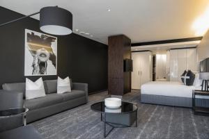 a living room with a couch and a bed at The Capital 15 on Orange Hotel & Spa in Cape Town