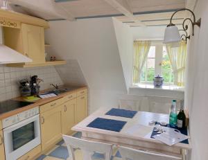 una pequeña cocina con mesa y fregadero en Friesenhof, Haus Hafis Wohnung 8, en Nebel