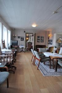 a large room with chairs and tables and a television at Grong Gård Guesthouse in Grong