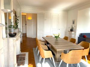 a dining room with a wooden table and chairs at Marvellous Sunbathed 3BR at the heart of Paris in Paris