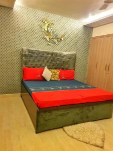 a bedroom with a bed with red pillows on it at Luxury Moradabad Homestay in Morādābād