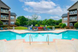 a large swimming pool in a apartment complex with patio furniture at Open and Brilliant 2BR with Balcony and Gym in Charlotte