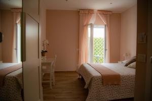 1 dormitorio con 2 camas y ventana en Il Granello, en Fiumicino