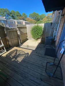 a backyard with a fence and a wooden floor at Va Beach Zen town house in Virginia Beach