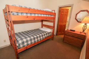 a bedroom with two bunk beds and a mirror at Mountainback #12, Loft in Mammoth Lakes
