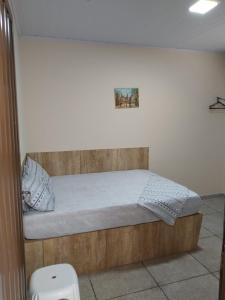 ein Schlafzimmer mit einem Bett mit einem hölzernen Kopfteil in der Unterkunft LOCANDA DA SERRA - Aptos Mobiliados e Suítes por Temporada in Barra do Garças