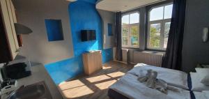 una camera da letto con pareti blu, un letto e un lavandino di Hotel Jerabek a Praga