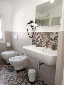 La salle de bains blanche est pourvue d'un lavabo et de toilettes. dans l'établissement Il Giardino di Ambra Casa Vacanze indipendente, à Viterbe