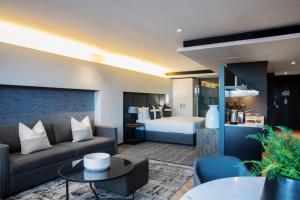 un soggiorno con divano e letto di The Capital 15 on Orange Hotel & Spa a Città del Capo