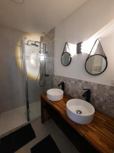 a bathroom with a sink and two mirrors at GITE CHEZ BERTHE in Pontfarcy
